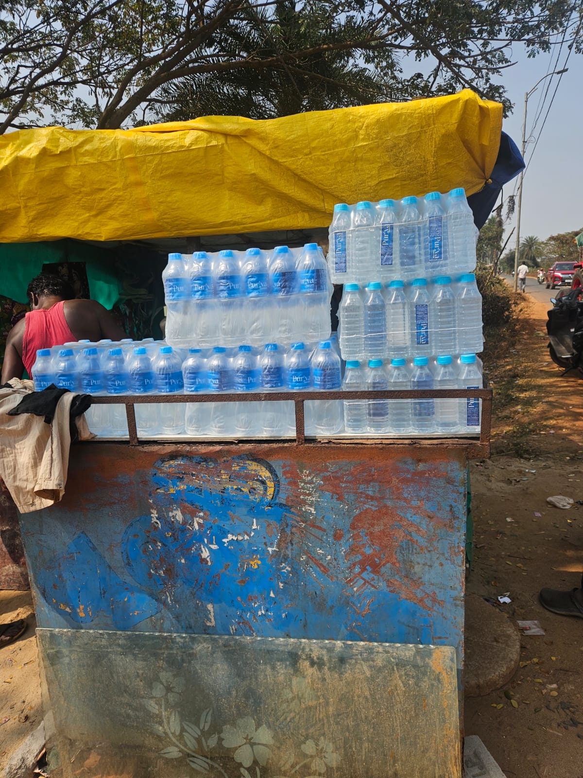 Hand holding Puriva Water bottle at sunset